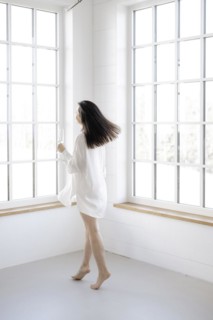 Attractive woman in a white shirt in front of a window