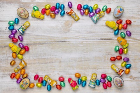 Frame of colourful Easter sweets on wood