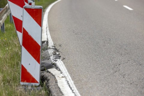 Country road in poor condition with lowered verge