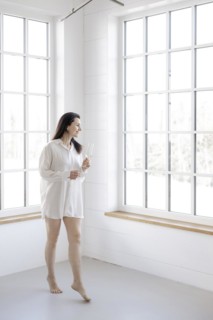 Attractive woman in a white shirt in front of a window
