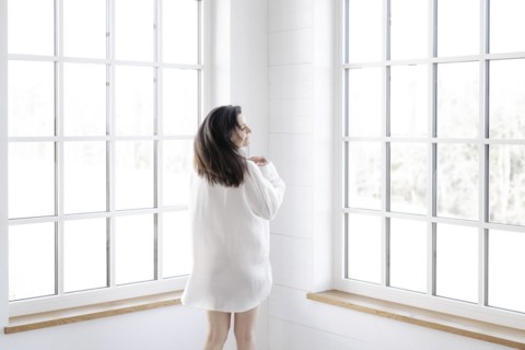 Attractive woman in a white shirt in front of a window