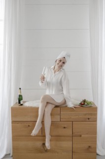Portrait of an attractive woman with a towel on her head drinking champagne