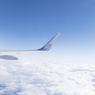 View of the wing of a Lufthansa aircraft over a sea of clouds