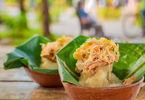 Close-up of two vigorones served on a wooden table. The vigoron typical food of Granada