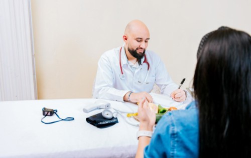 Nutritionist man giving consultation to woman patient in office