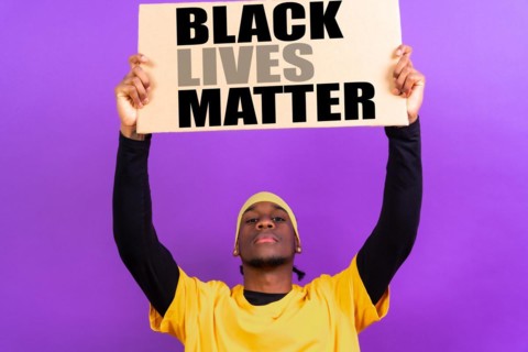 Black ethnic man in yellow clothes on a purple background