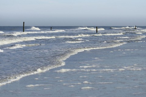 Leaking waves on the North Beach with boundary piles