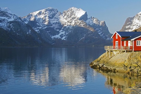 Rorbuer and high mountains reflected in a fjord