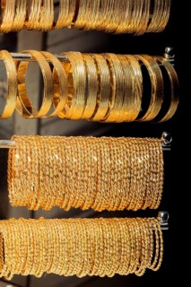 Shop display of dozens of golden bracelets and bangles