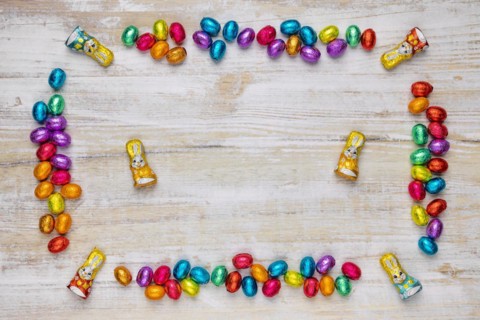 Frame of colourful Easter sweets on wood