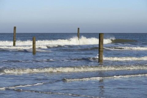 Leaking waves on the North Beach with boundary piles