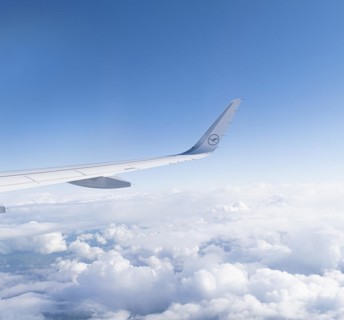 View of the wing of a Lufthansa aircraft over a sea of clouds