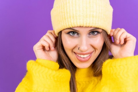 Close up portrait of young caucasian woman in yellow sweater isolated on yellow background