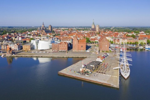 Aerial view over public aquarium Ozeaneum and three-mast barque Gorch Fock docked in harbour of the city Stralsund