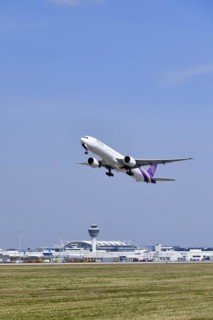 Take-off Thai Airways Boeing B777 Dreamliner with tower in the background