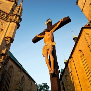Jesus Christ on the cross between Erfurt Cathedral and Severi Church in early morning light