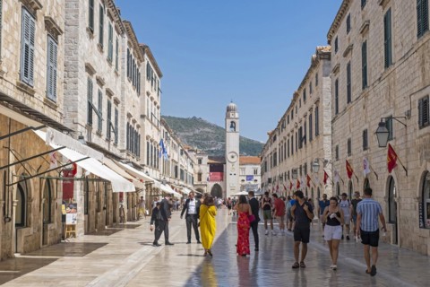 Bell tower and tourists shopping in Stradun