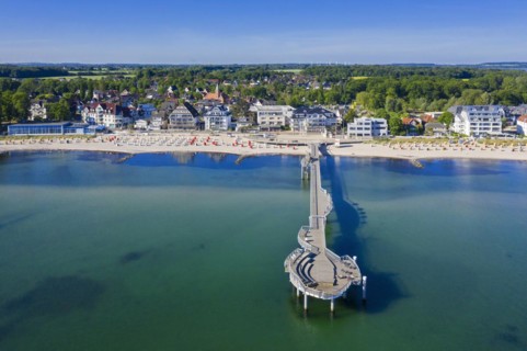 Aerial view over wooden pleasure pier and hotels at seaside resort Niendorf along the Baltic Sea