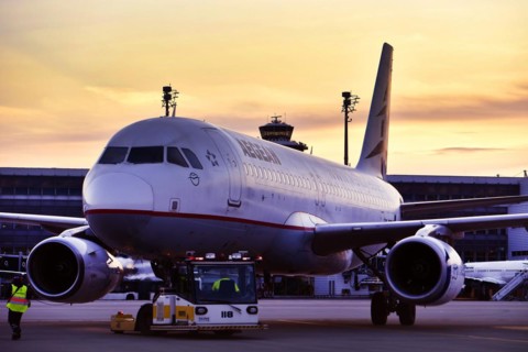 Agean Airlines aircraft towing in front of Terminal 2 in the sunset