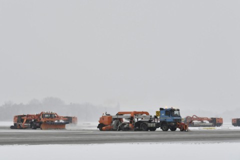 Road sweepers and snow ploughs clear snow on the taxiways and Runway North