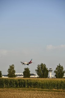 Eurowings Airbus A320 landing on Runway North with Tower Munich Airport and cornfield in the foreground