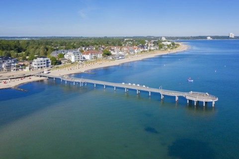 Aerial view over wooden pleasure pier and hotels at seaside resort Niendorf along the Baltic Sea