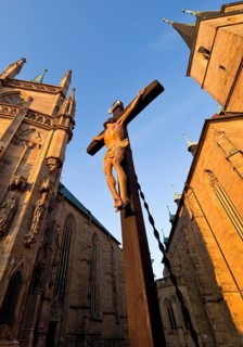 Jesus Christ on the cross between Erfurt Cathedral and Severi Church in early morning light