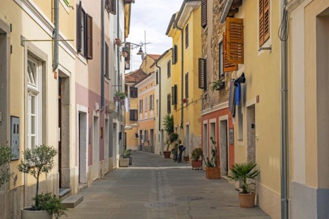 Alley with pastel coloured houses in the town Izola