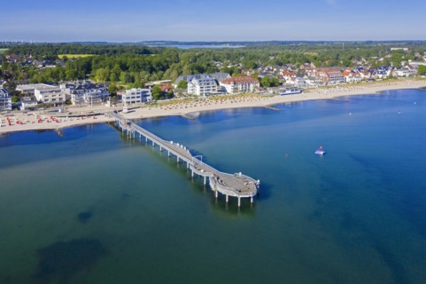 Aerial view over wooden pleasure pier and hotels at seaside resort Niendorf along the Baltic Sea