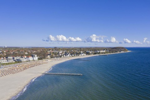 Aerial view over sandy beach with roofed wicker beach chairs at seaside resort Travemuende