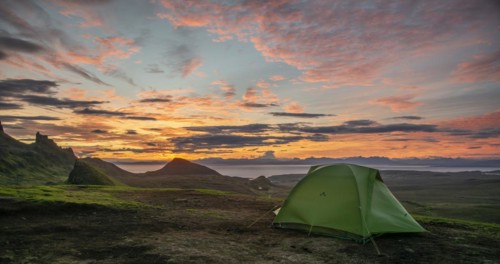 Tent overlooking rocky landscape Quiraing at sunrise