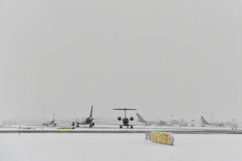 Aircraft in wait in winter snow flurry for de-icing and take-off clearance