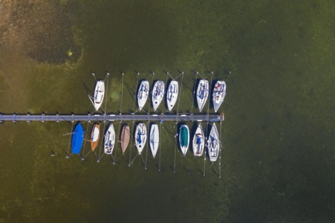 Aerial view over sailing boats moored at wooden jetty in lake Ratzeburger