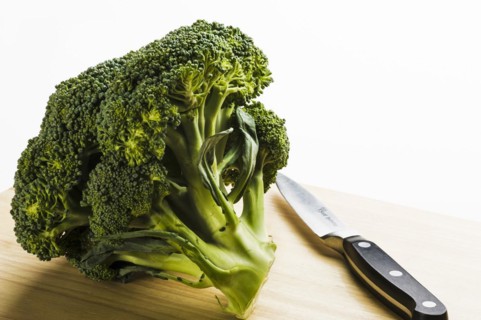 Broccoli head on wooden chopping board