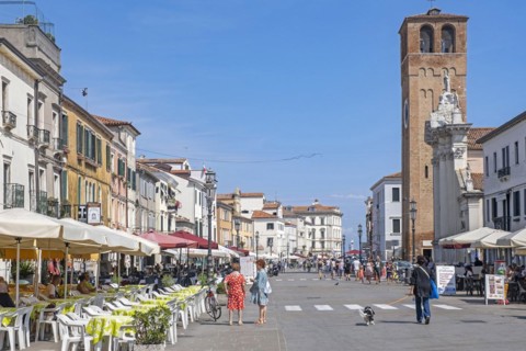 Bell tower and restaurants in the town Chioggia on small island at southern entrance to Venetian Lagoon near Venice