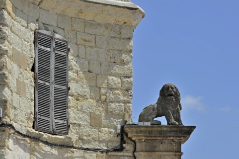 Sculpture of lion and closed window shutters at Auch