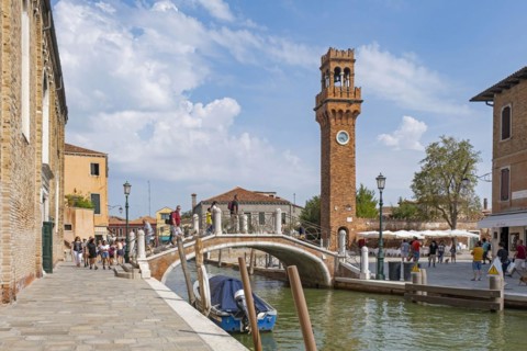 Clock tower and Ponte San Pietro Martire bridge over canal Rio dei Vetrai at Murano