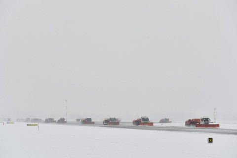 Road sweepers and snow ploughs clear snow on the taxiways and Runway North
