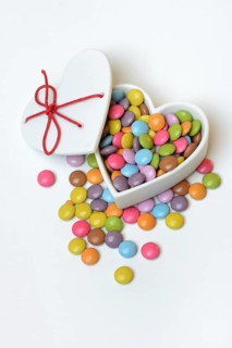 Chocolate lentils in heart-shaped container, Smartie