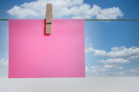 Colorful post it on a clothesline with cloudy sky in the background