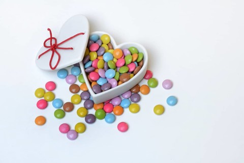 Chocolate lentils in heart-shaped container, Smartie