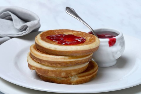 Pancake with raspberry jam and spoon