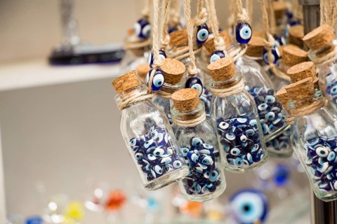 Little transparent glass bottle filled with blue evil eye beads