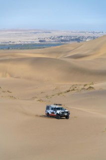 Off-road vehicle in sand dunes above the Orange River, also Oranjemund, Sperrgebiet National Park, also Tsau ÇKhaeb National Park, Namibia, Africa