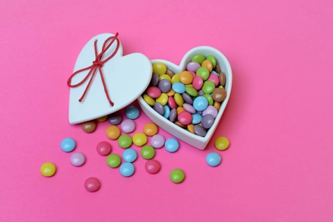 Chocolate lentils in heart-shaped container, Smartie