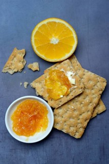 Orange marmalade in small bowls and on crispbread