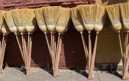Set of yellow straw broom in a bazaar