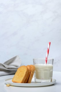 Rusk and glass of milk with drinking straw