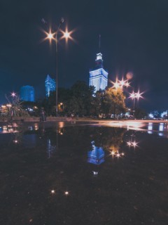 Night cityscape with reflections in the puddle