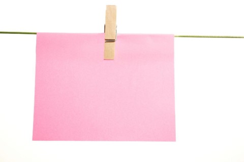 Sticky note hung with a clothespin on a clothesline with copy space and white background